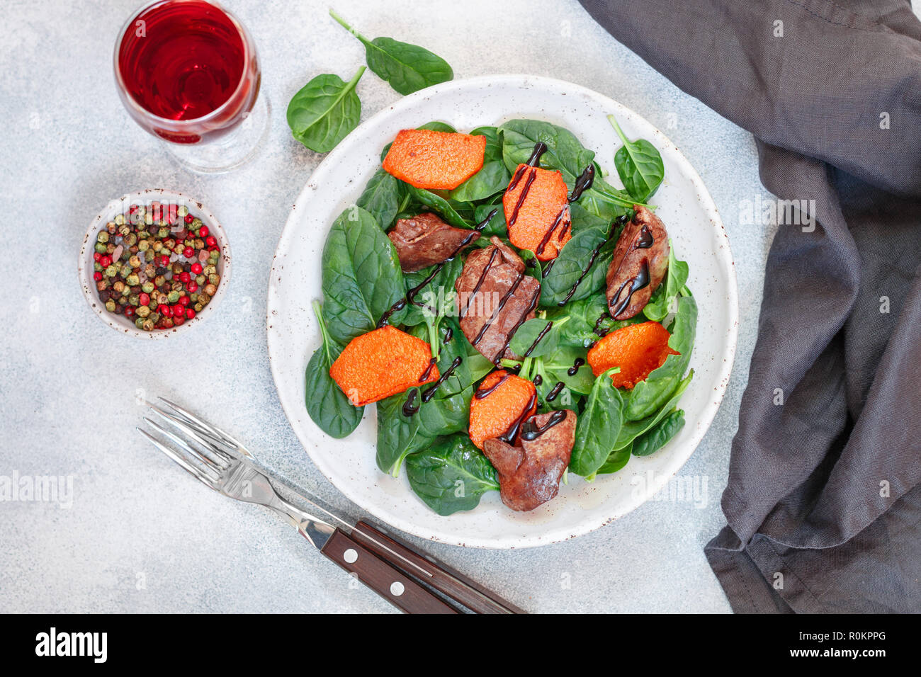 Salade tiède de foie de poulet cuit avec de la citrouille et aux épices et vinaigre balsamique. Délicieux dîner avec du vin rouge pour les gourmets. Selective focus, top vi Banque D'Images