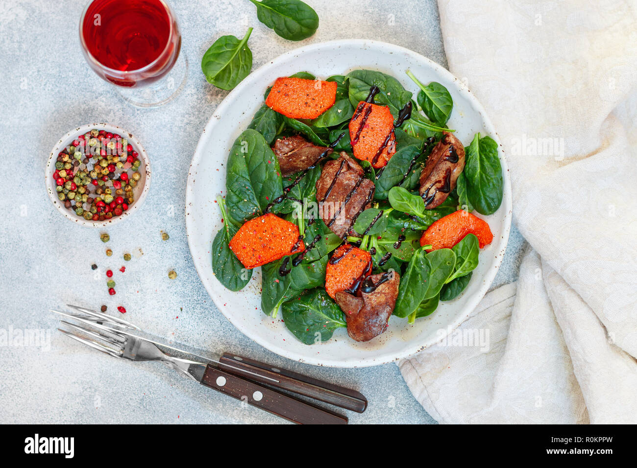 Salade tiède de foie de poulet cuit avec de la citrouille et aux épices et vinaigre balsamique. Délicieux dîner avec du vin rouge pour les gourmets. Selective focus, top vi Banque D'Images