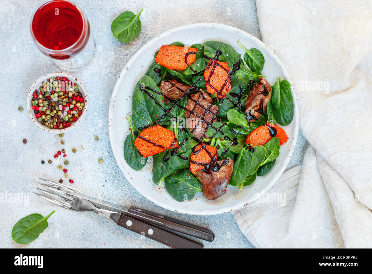 Salade tiède de foie de poulet cuit avec de la citrouille et aux épices et vinaigre balsamique. Délicieux dîner avec du vin rouge pour les gourmets. Selective focus, top vi Banque D'Images