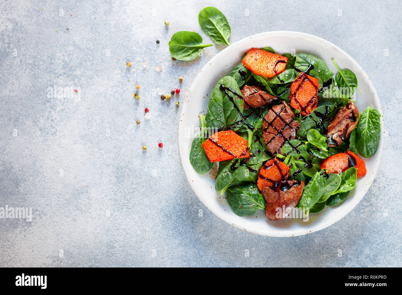 Salade tiède de foie de poulet cuit avec de la citrouille et aux épices et vinaigre balsamique. Délicieux dîner avec du vin rouge pour les gourmets. Selective focus, top vi Banque D'Images