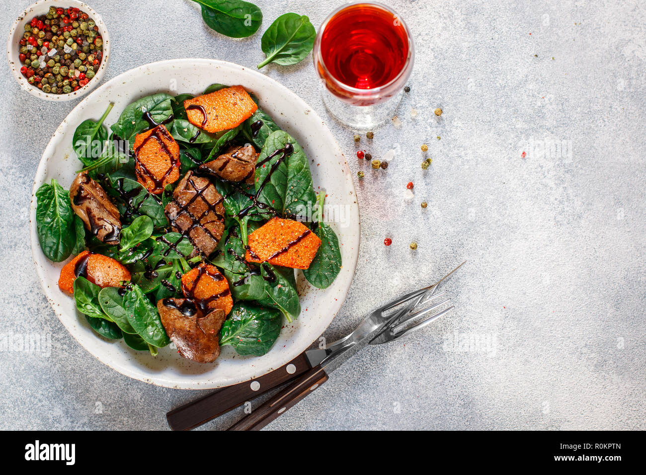 Salade tiède de foie de poulet cuit avec de la citrouille et aux épices et vinaigre balsamique. Délicieux dîner avec du vin rouge pour les gourmets. Selective focus, top vi Banque D'Images