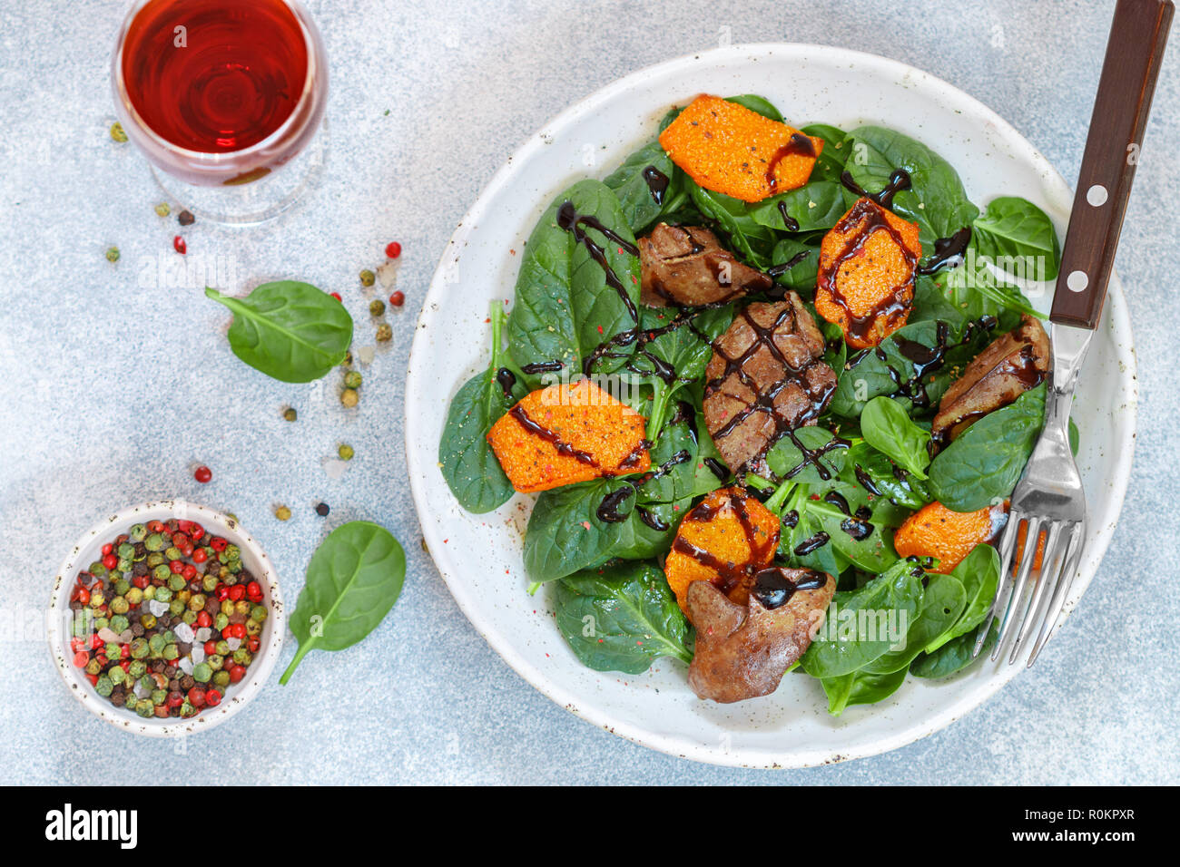 Salade tiède de foie de poulet cuit avec de la citrouille et aux épices et vinaigre balsamique. Délicieux dîner avec du vin rouge pour les gourmets. Selective focus, top vi Banque D'Images