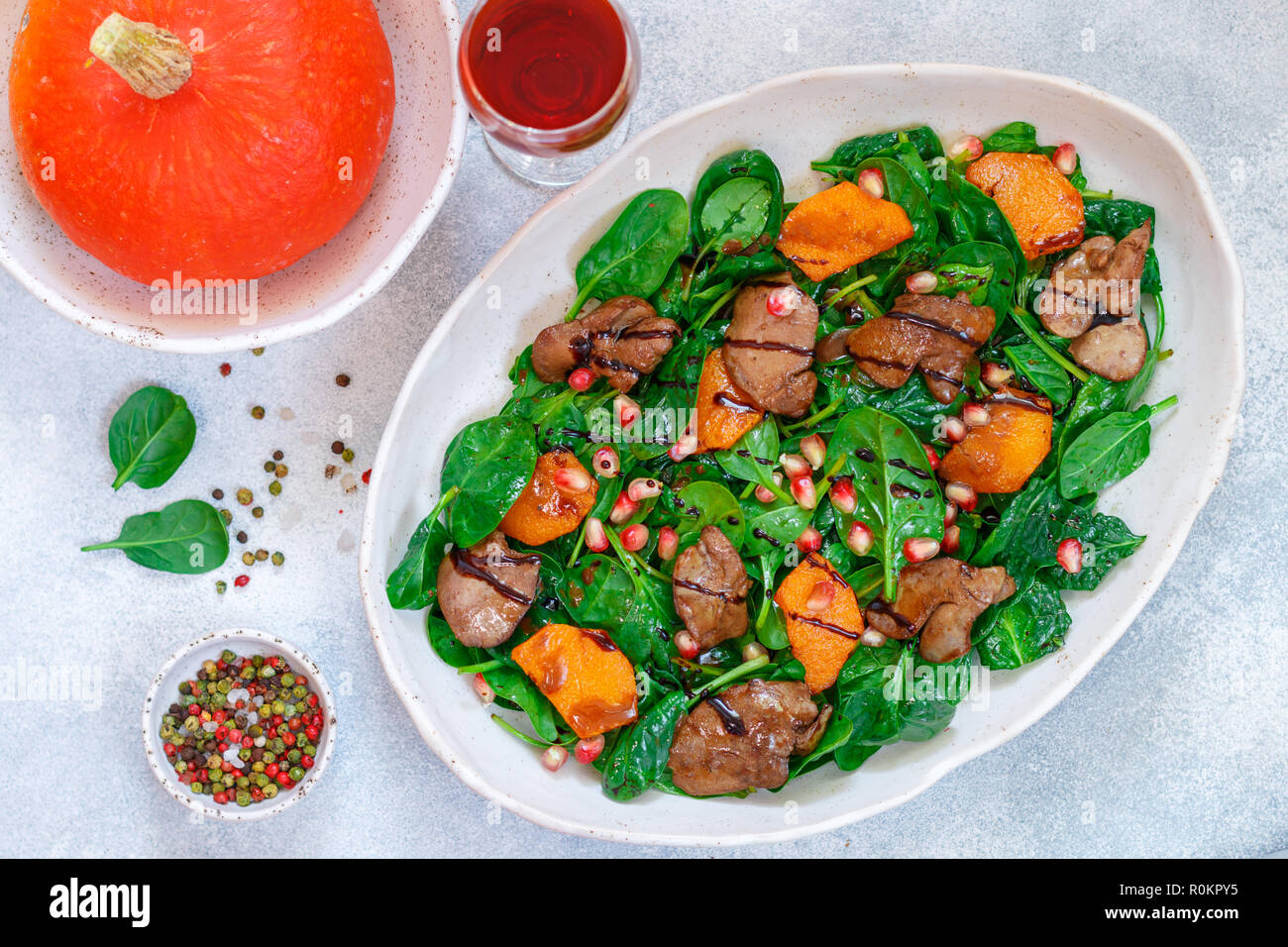 Salade tiède de foie de poulet cuit avec, citrouille et grenade d'épices et de vinaigre balsamique. Délicieux dîner avec du vin rouge pour les gourmets. Selective Banque D'Images
