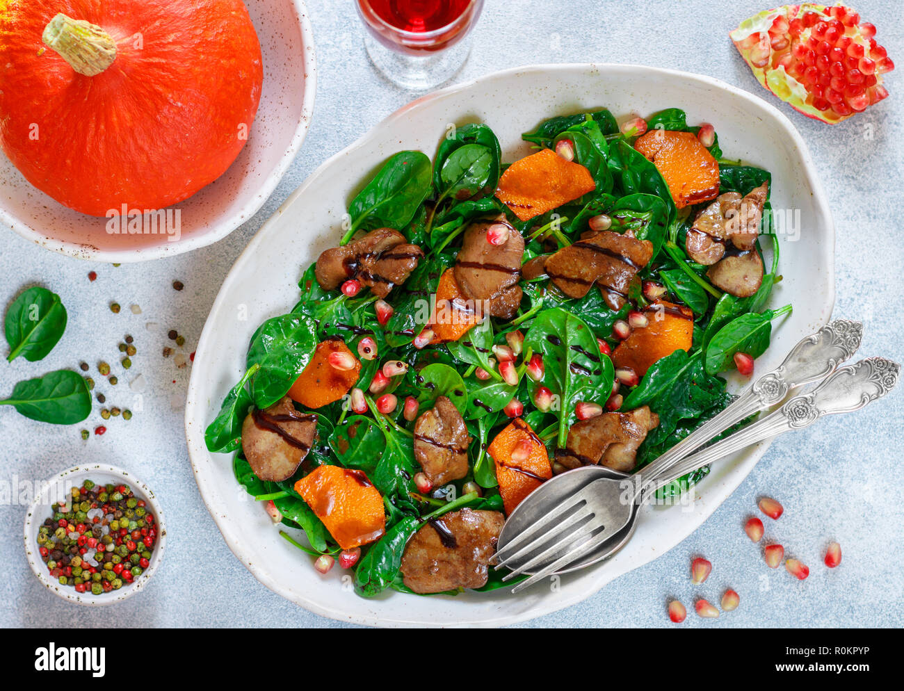 Salade tiède de foie de poulet cuit avec, citrouille et grenade d'épices et de vinaigre balsamique. Délicieux dîner avec du vin rouge pour les gourmets. Selective Banque D'Images