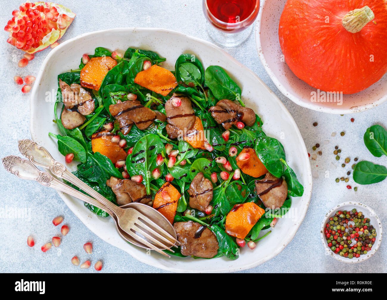 Salade tiède de foie de poulet cuit avec, citrouille et grenade d'épices et de vinaigre balsamique. Délicieux dîner avec du vin rouge pour les gourmets. Selective Banque D'Images