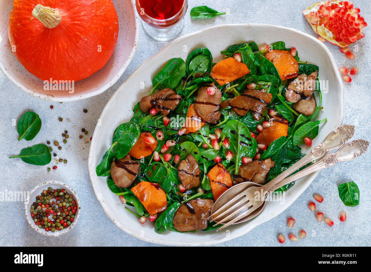Salade tiède de foie de poulet cuit avec, citrouille et grenade d'épices et de vinaigre balsamique. Délicieux dîner avec du vin rouge pour les gourmets. Selective Banque D'Images