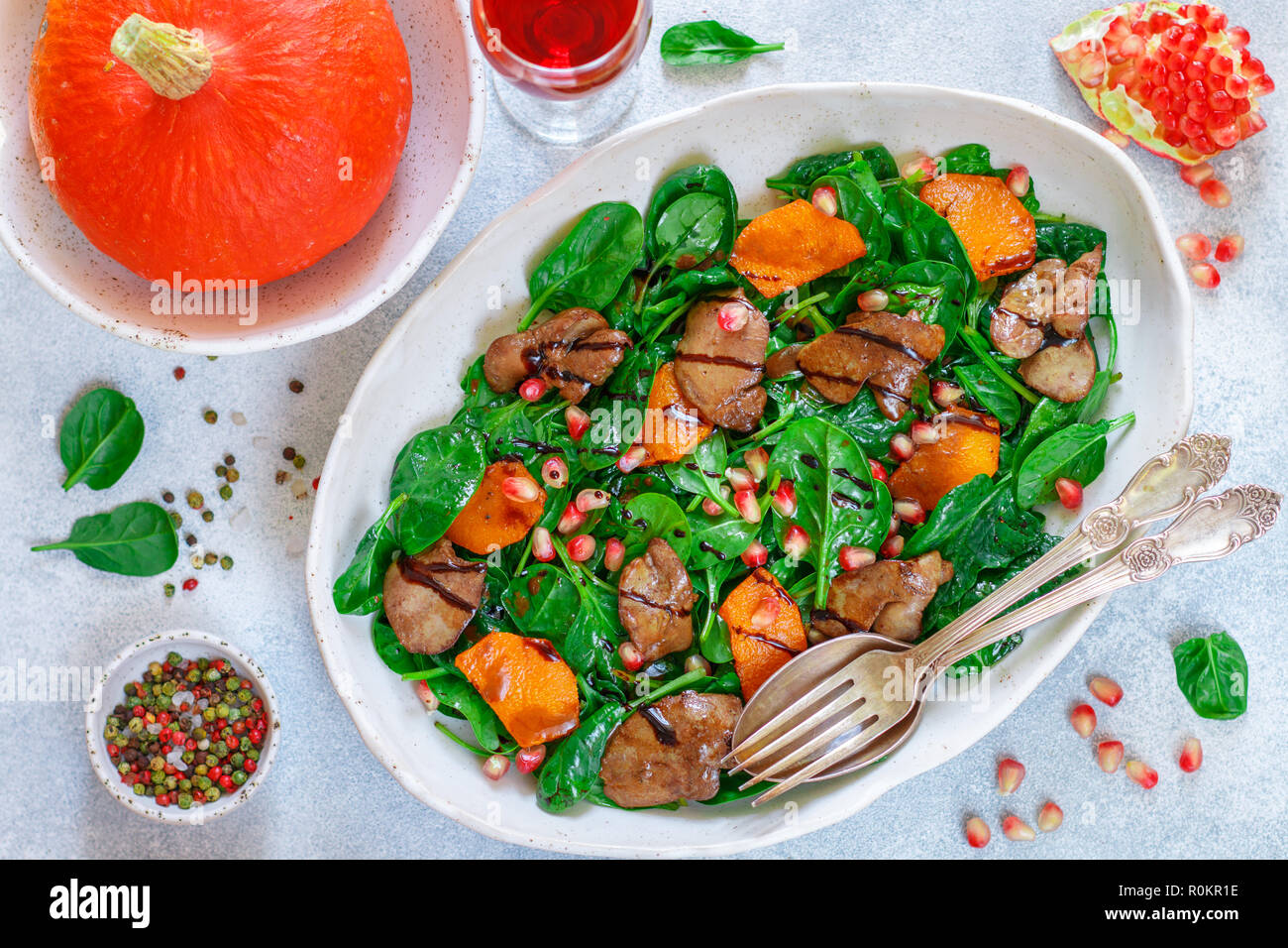 Salade tiède de foie de poulet cuit avec, citrouille et grenade d'épices et de vinaigre balsamique. Délicieux dîner avec du vin rouge pour les gourmets. Selective Banque D'Images