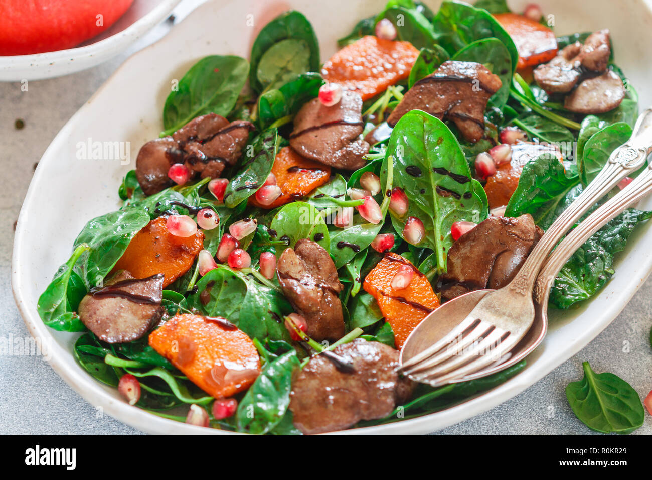 Salade tiède de foie de poulet cuit avec, citrouille et grenade d'épices et de vinaigre balsamique. Délicieux dîner pour les gourmets. Selective focus Banque D'Images