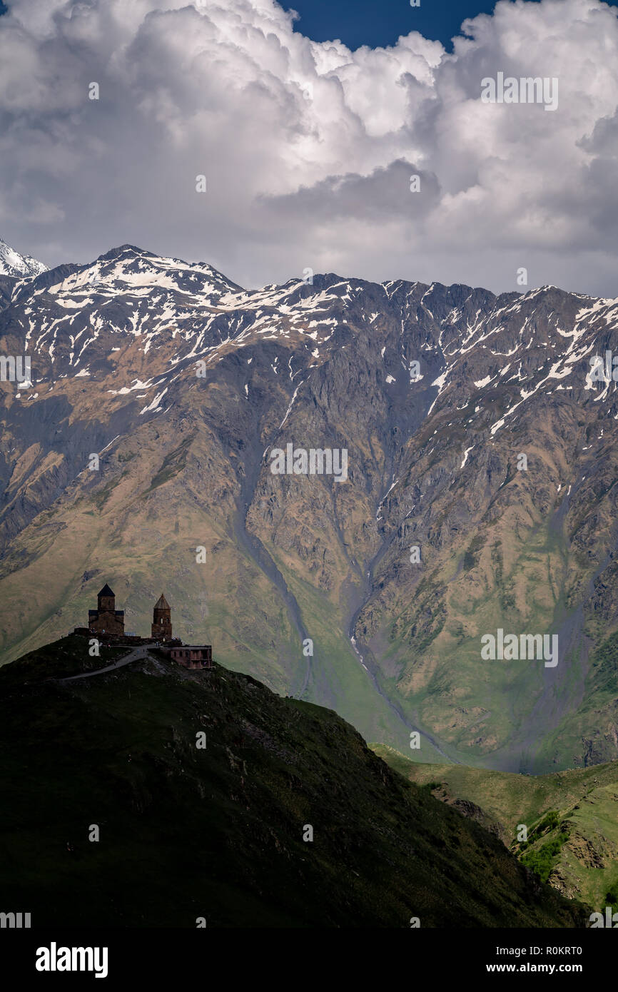 Église Gergeti spectaculaire perché sur une colline dans les montagnes du Caucase, Kazbegi, Géorgie. Banque D'Images