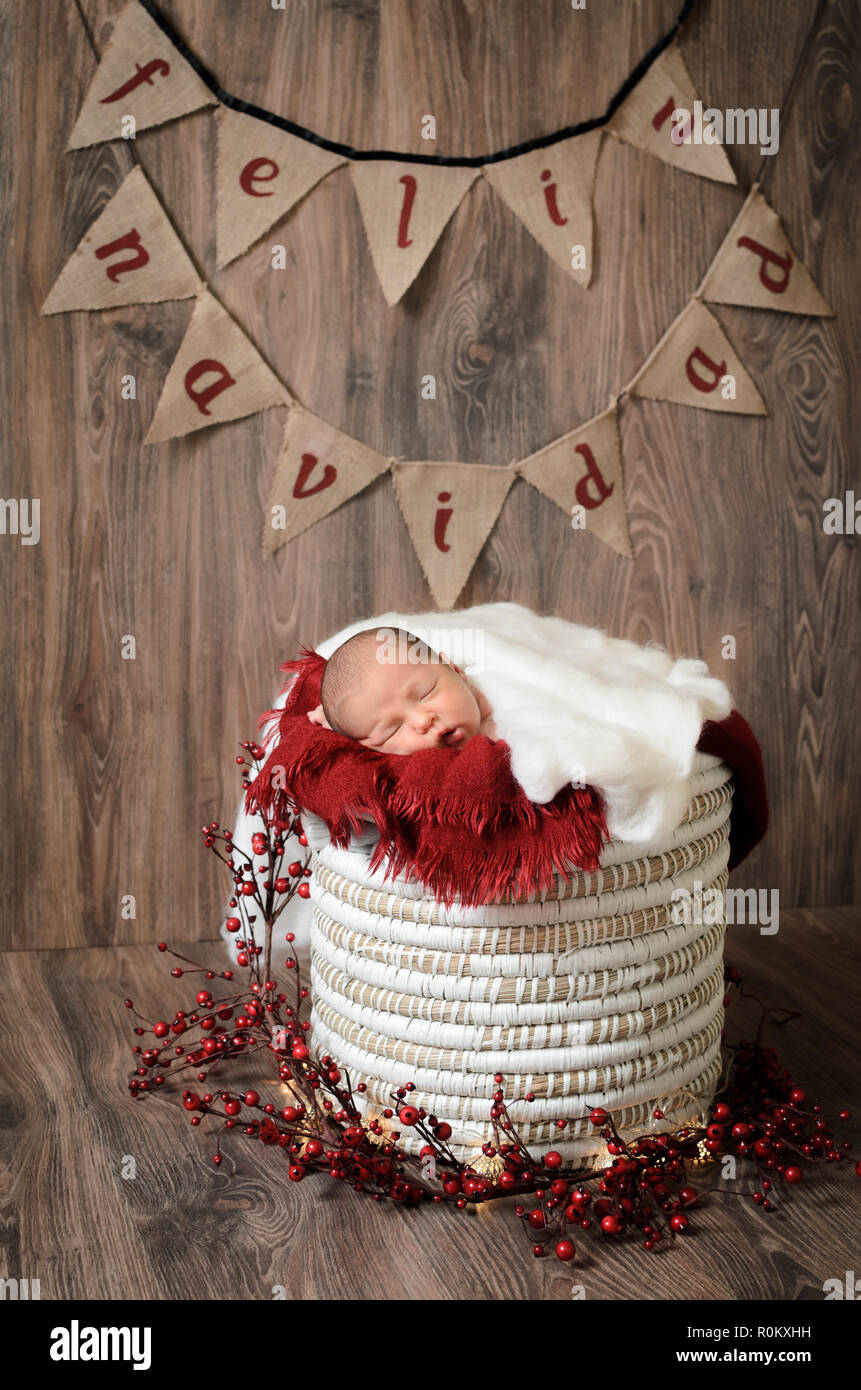 Joli bébé dormir sur un panier avec brown, fond de bois et joyeux Noël lettres. Banque D'Images