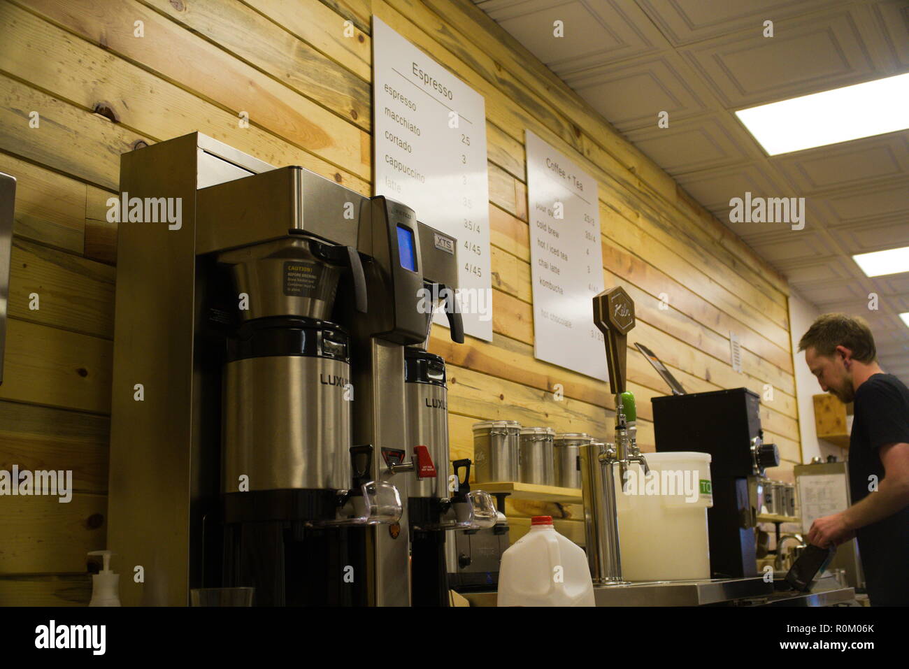 Un barista moud les grains de café en arrière-plan. Banque D'Images