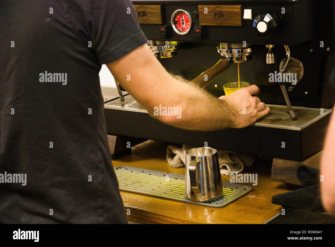 Un barista brasse un shot d'expresso pour un café d'une machine à expresso. Banque D'Images