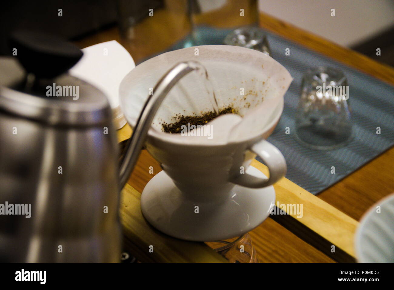 L'eau d'une bouilloire est versé dans un filtre à café dans une tasse à café. Le Barista apporte une verser sur le café. Banque D'Images