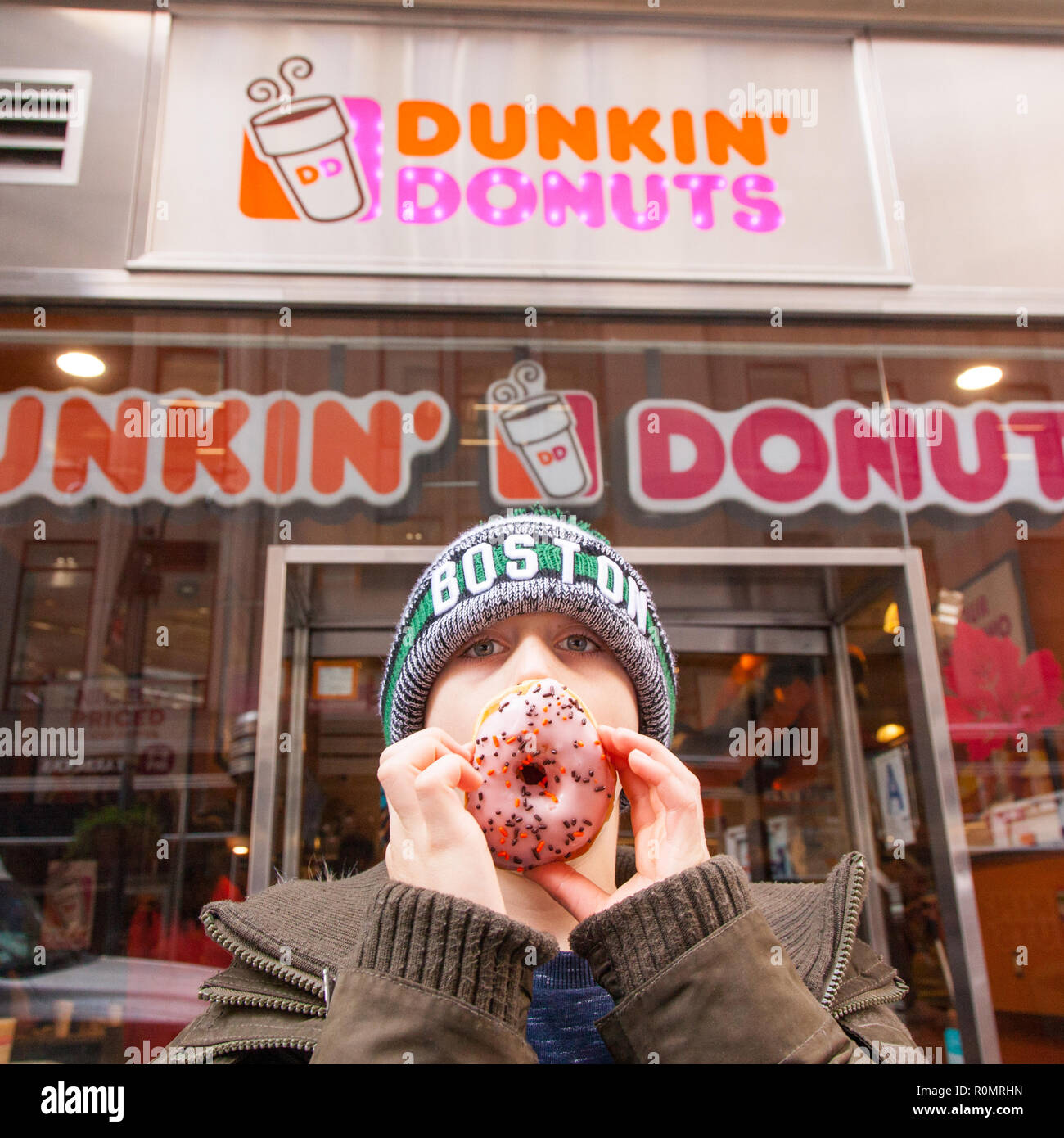 Un garçon de neuf ans à l'extérieur du Dunkin' Donuts store 316 W 34th St, New York City, États-Unis d'Amérique. Banque D'Images