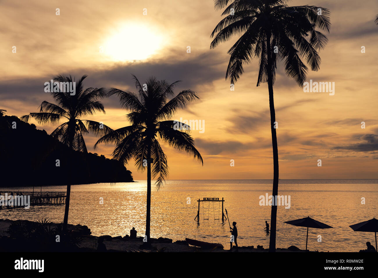 Nature paysage incroyable plage tropicale avec palmiers et swing en mer au coucher du soleil Banque D'Images