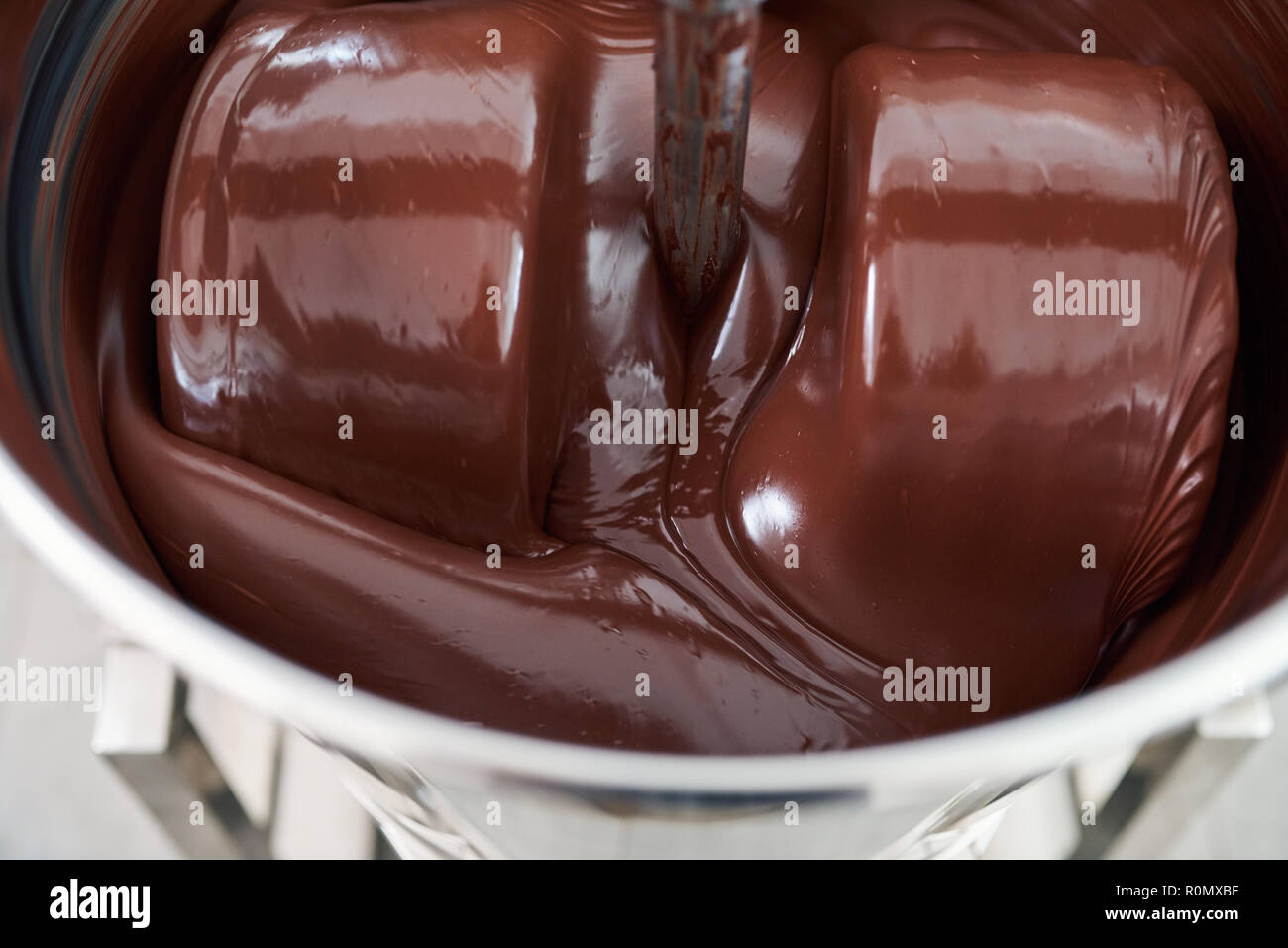 Le chocolat fondu en remuant dans un mélangeur en acier inoxydable Banque D'Images