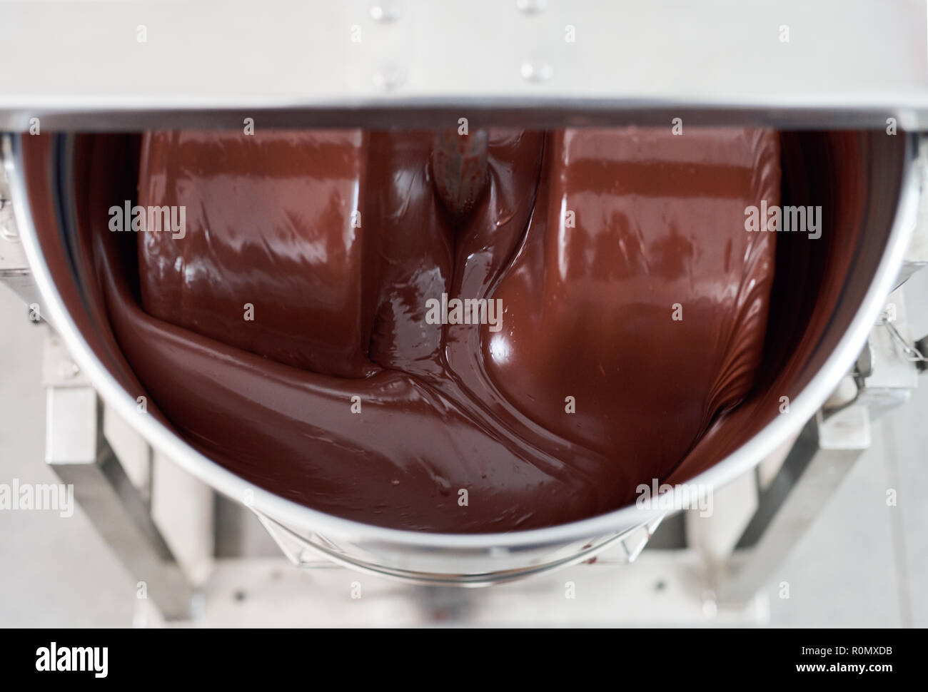 Le mélange de chocolat fondu dans un mélangeur en acier inoxydable Banque D'Images