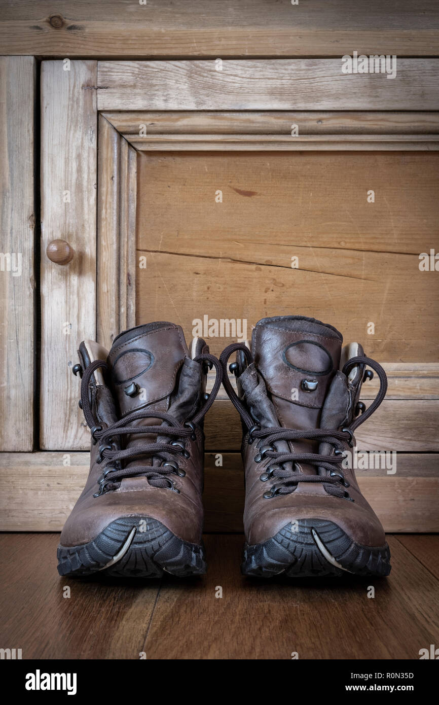 Une paire de bottes de randonnée en cuir sur un plancher en bois. Banque D'Images
