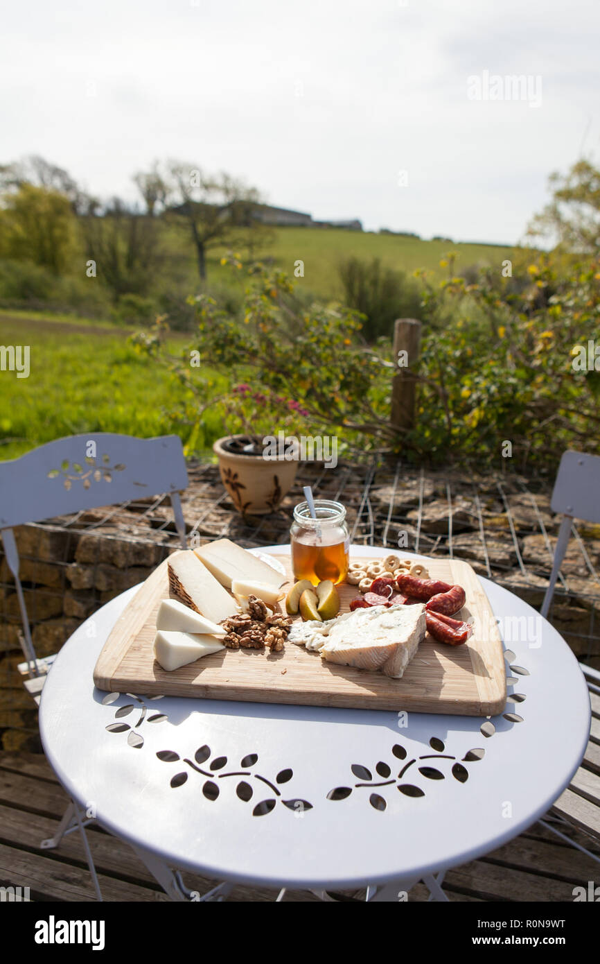 Itanian avec fromages miel, noix, fruits et viandes dans un jardin de campagne. Banque D'Images