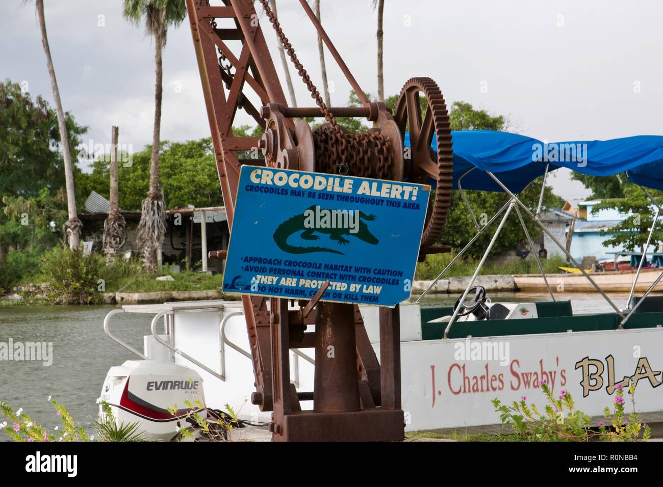 Un panneau bleu qui dit 'Crocodile Alert' sur Black River safari croisière dans la paroisse de St Elizabeth, Jamaïque, Banque D'Images