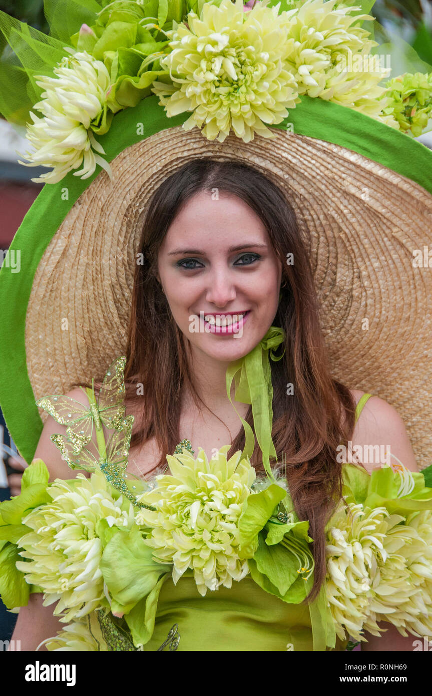 Jolie jeune femme portant un chapeau fleuri coloré lors d'un festival de fleurs de Madère. Funchal Madère Banque D'Images