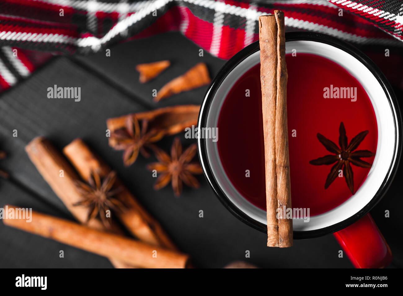 Vin chaud de Noël aux épices dans la tasse rouge sur fond de bois. Banque D'Images
