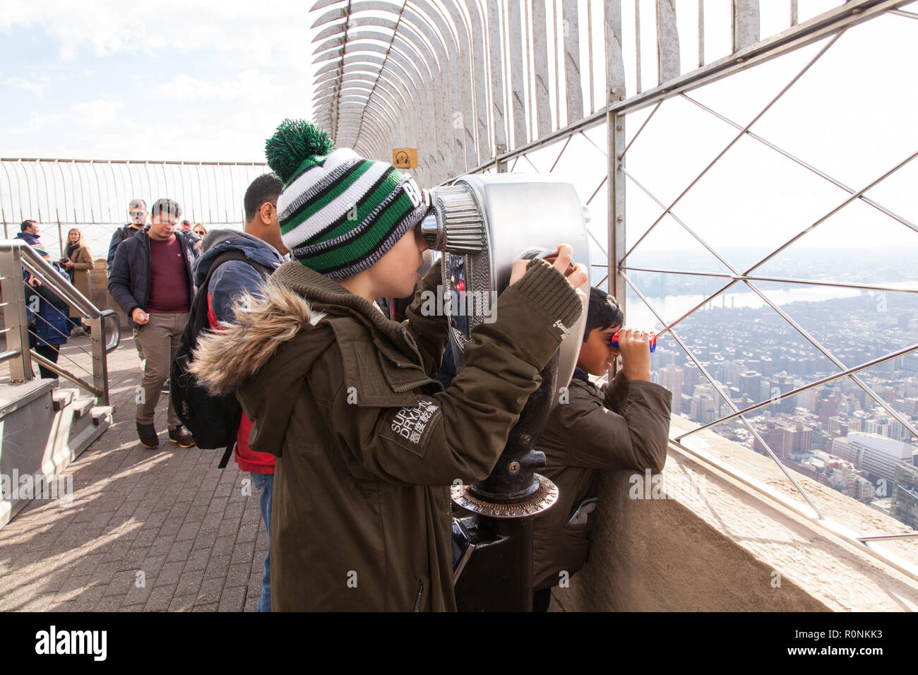 Un garçon de neuf ans avec des jumelles à monnayeur, Empire State Building, New York City, États-Unis d'Amérique. Banque D'Images