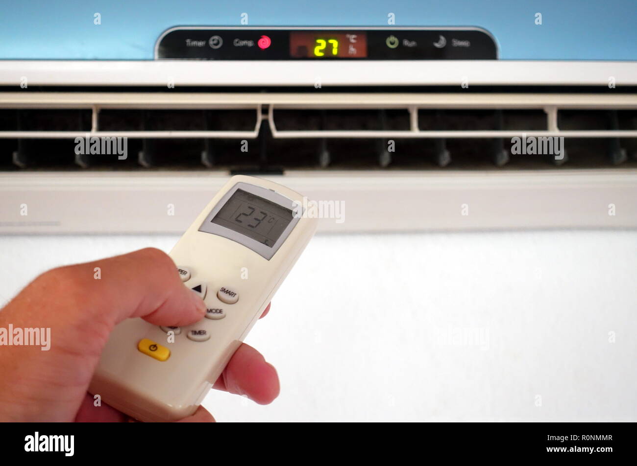 Quelqu'un la modification des paramètres d'un AC ou d'unité d'air conditionné avec télécommande - se concentrer sur la télécommande Banque D'Images