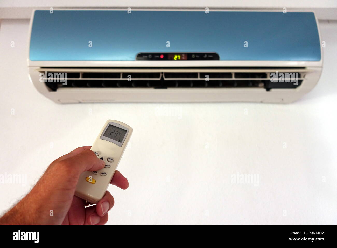 Quelqu'un la modification des paramètres d'un AC ou d'unité d'air conditionné avec télécommande - se concentrer sur la télécommande - l'espace de copie pour le texte Banque D'Images