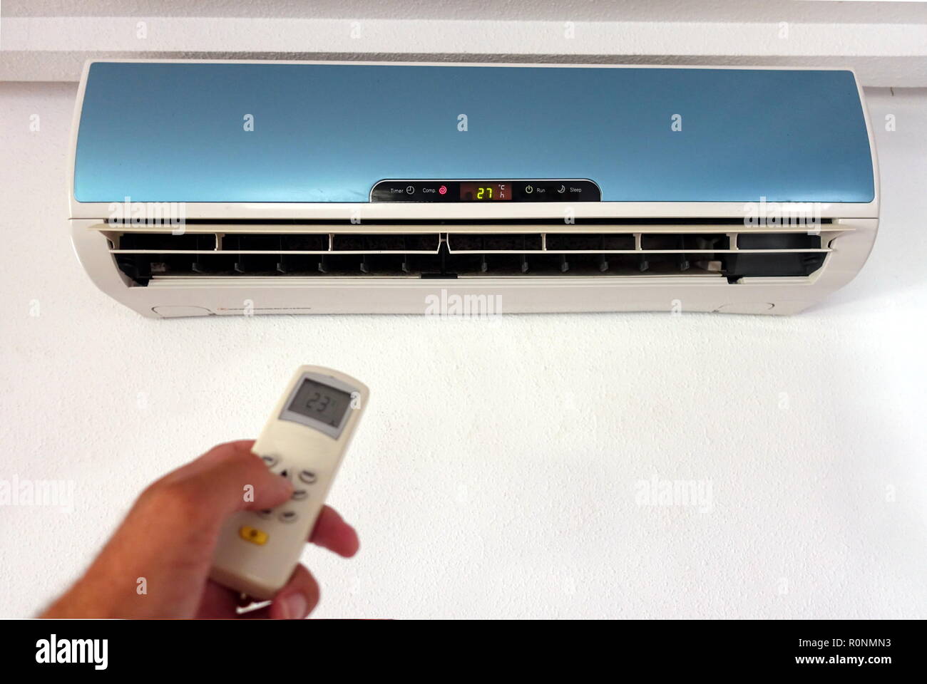 Quelqu'un la modification des paramètres d'un AC ou d'unité d'air conditionné avec télécommande - l'accent sur l'unité murale - copie du texte pour l'espace Banque D'Images