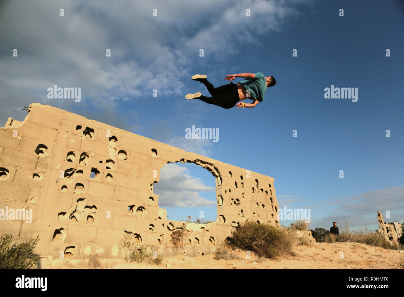 Un jeune Palestinien vu pendant son saut Parkour pratique au pierres déchirées par la guerre. Gaza est l'un des plus hauts taux de chômage des jeunes dans le monde avec plus de 80 % des jeunes de moins de 30 ans sont sans emploi, Parkour est un des moyens pour les jeunes de passer leurs longues après-midi et se maintenir en forme. Banque D'Images