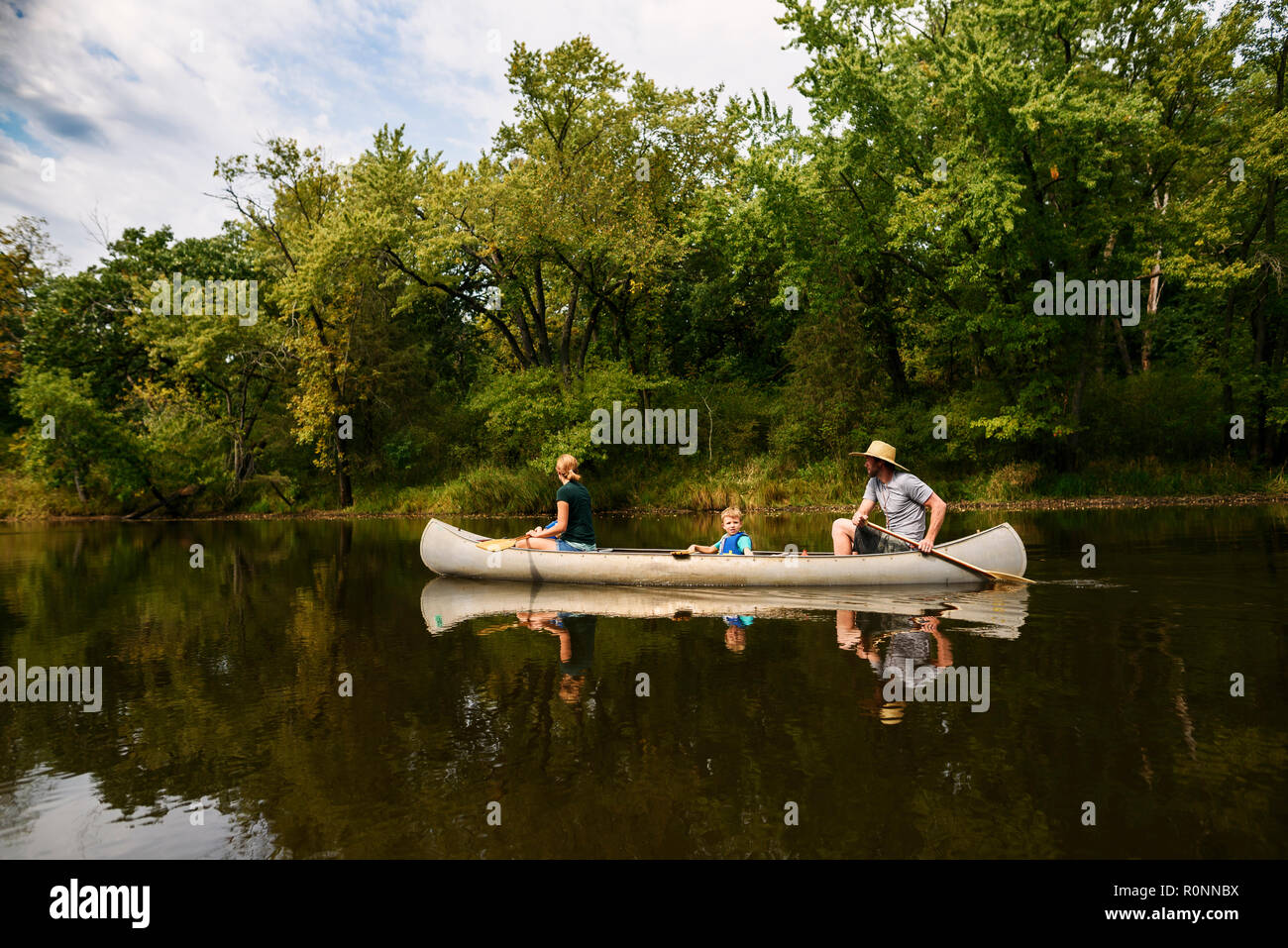 Famille avec un enfant du canoë sur une rivière, United States Banque D'Images