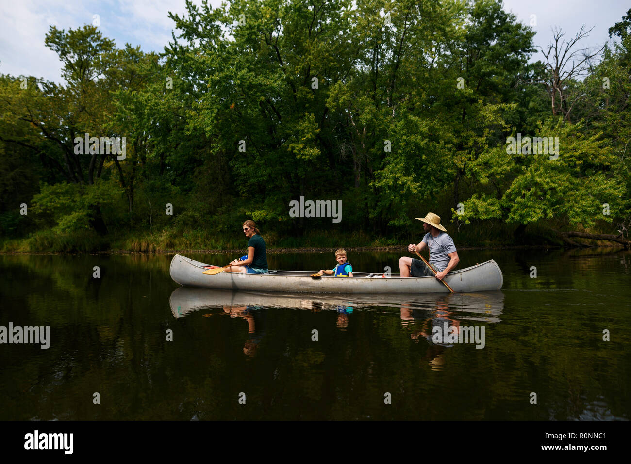 Famille avec un enfant du canoë sur une rivière, United States Banque D'Images