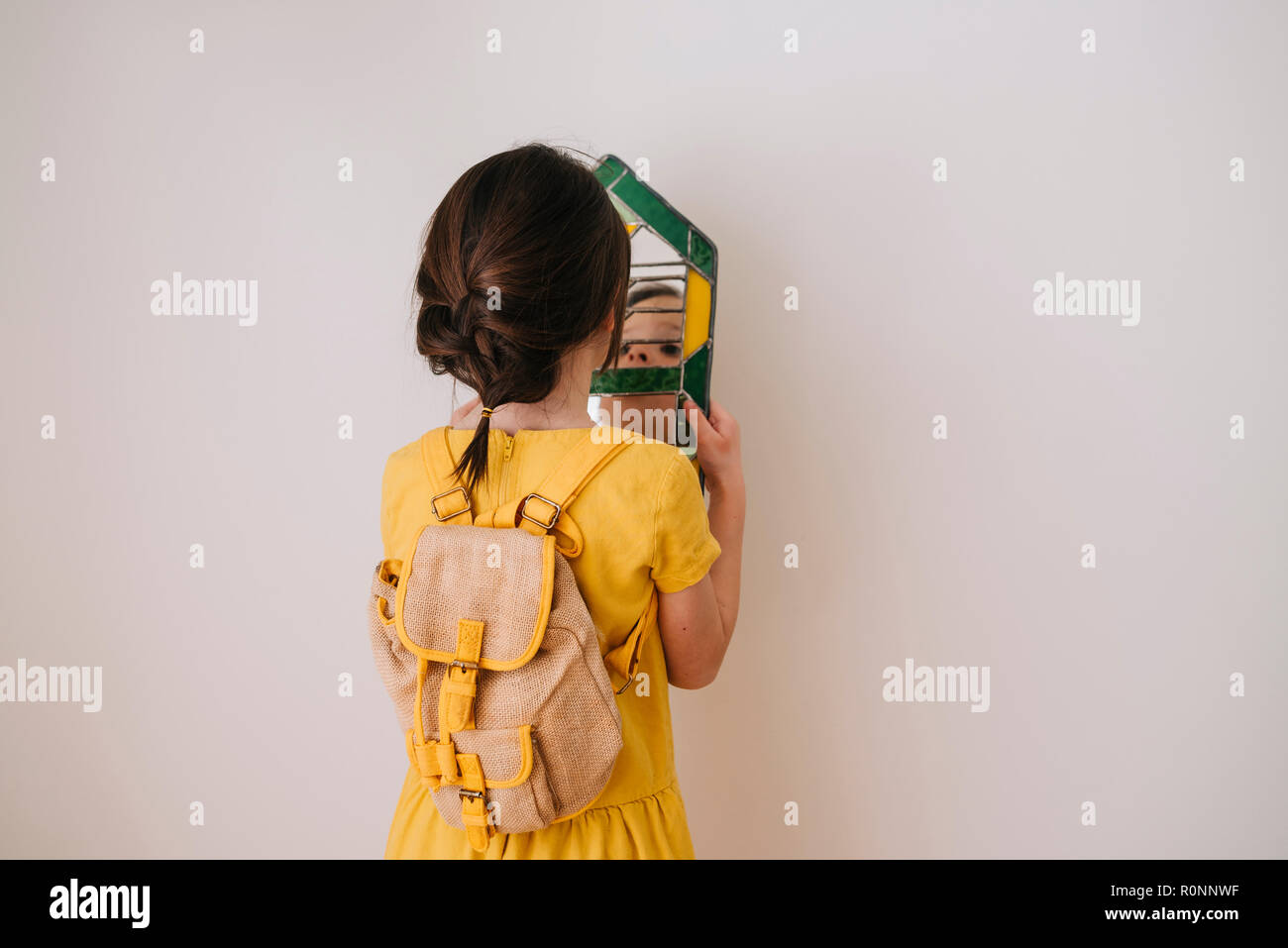 Vue arrière d'une fille à son reflet dans un miroir Banque D'Images