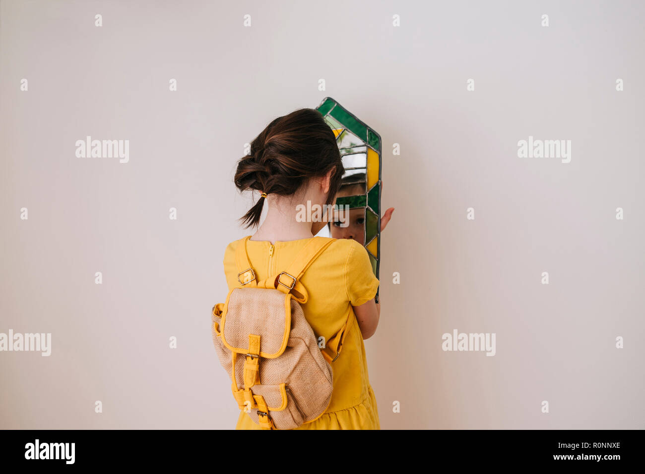 Vue arrière d'une fille à son reflet dans un miroir Banque D'Images