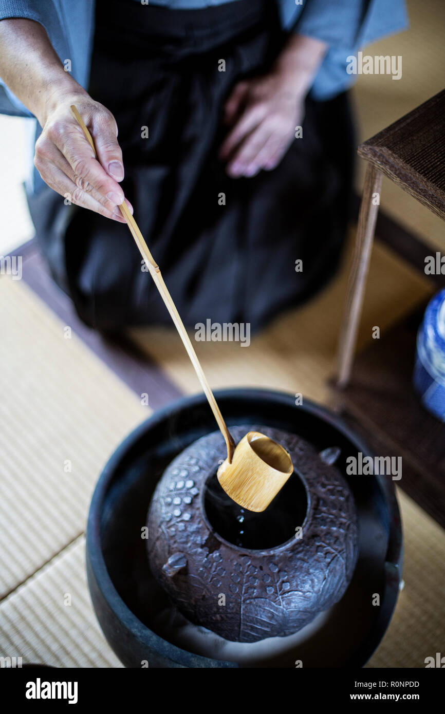 High angle close up de cérémonie du thé japonaise traditionnelle, l'homme à l'aide d'une louche Hishaku, un bambou, de verser de l'eau chaude. Banque D'Images