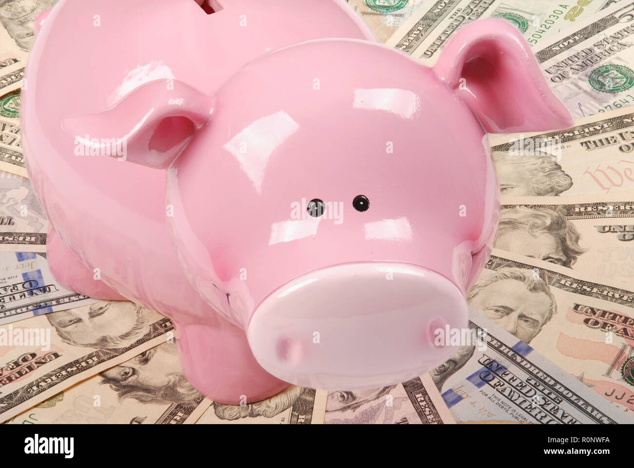 Pink piggy bank sur fonds blancs sur mandala kaleidoscope de l'argent. Résumé Contexte de l'argent trame répéter mandala circle. Banque D'Images