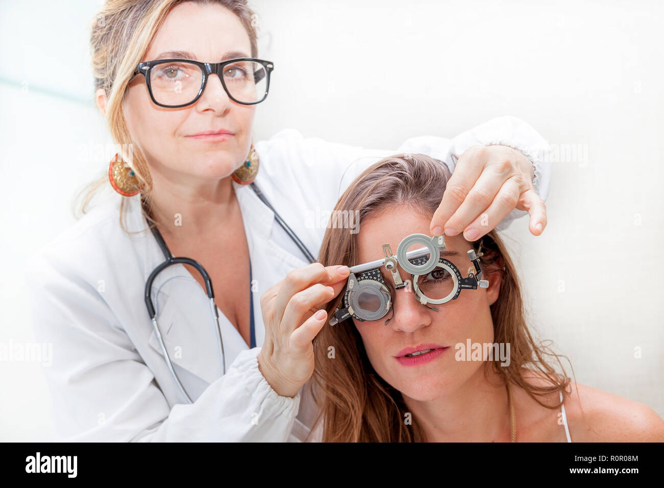 Spécialiste en ophtalmologie à l'essai de nouvelles lentilles sur un patient avec phoropter Banque D'Images