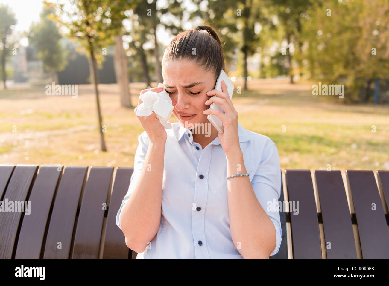 Jeune Femme Triste Pleure Quand Vous Parlez Au Telephone Mobile Dans Le Parc Sur Un Banc Photo Stock Alamy