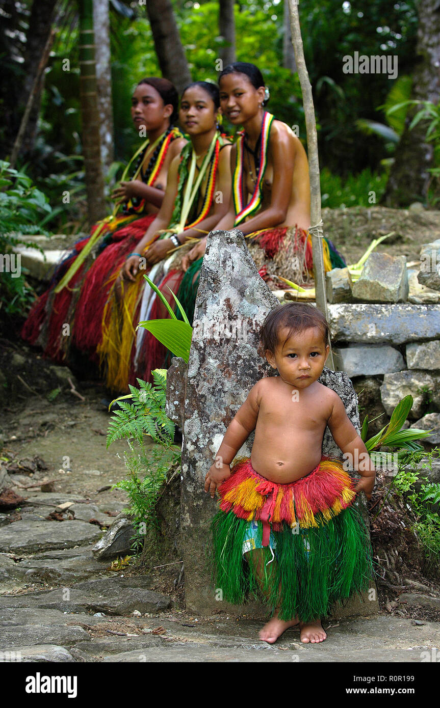 Einheimische Frauen und kleines Mädchen tragen Baströcke, Yap, Mikronesien | femmes vêtements traditionnels avec petite fille portant des jupes de hula, Yap, Mi Banque D'Images