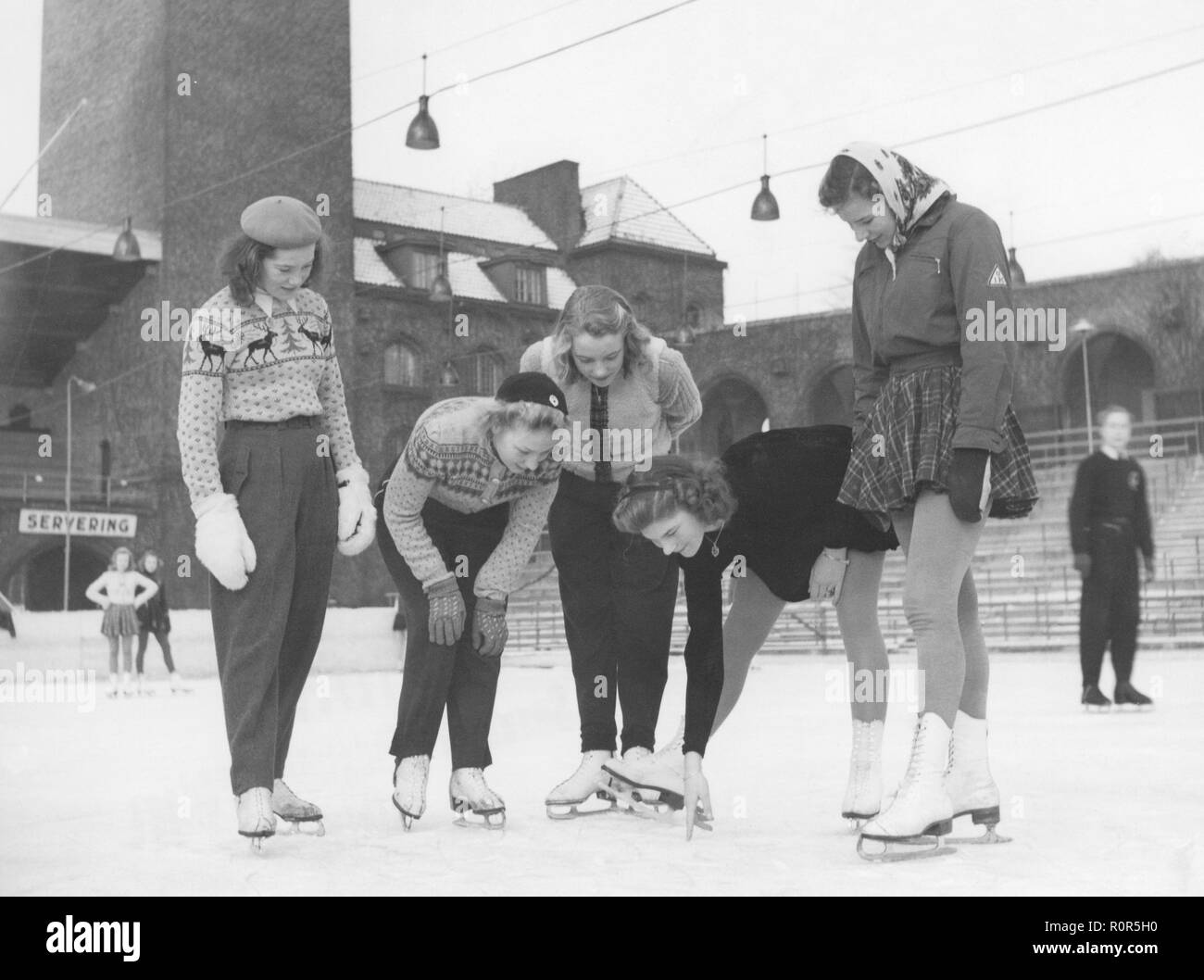 Patineurs sur glace féminin dans les années 40. Deuxième à droite de patinage sur glace Britta råhlén champion avec des amis sur le stade de Stockholm, où la regarder quelque chose dans la glace. Suède 1940 Banque D'Images