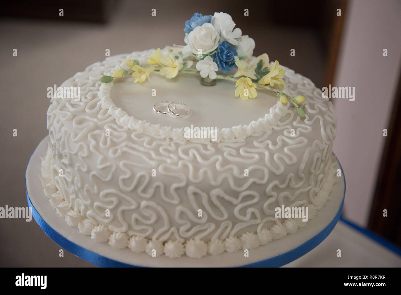Close up de gâteau de mariage, montrant décoration sur le dégivrage et d'antigivrage des fleurs sur le dessus du gâteau de mariage Banque D'Images
