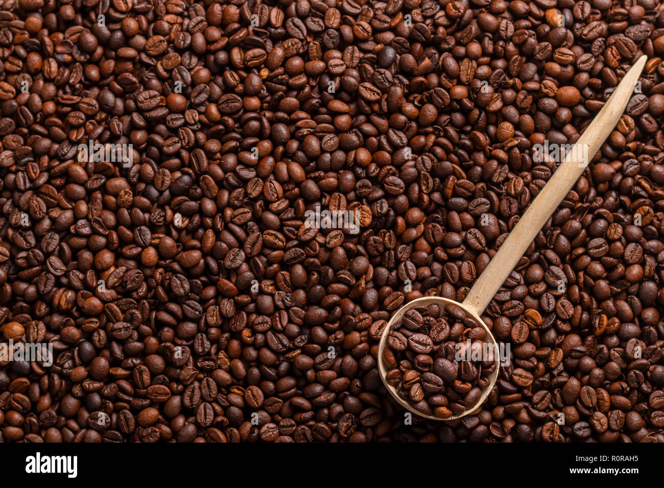 Vue de dessus de la cuillère de bois avec du café allongé sur les grains de café Banque D'Images