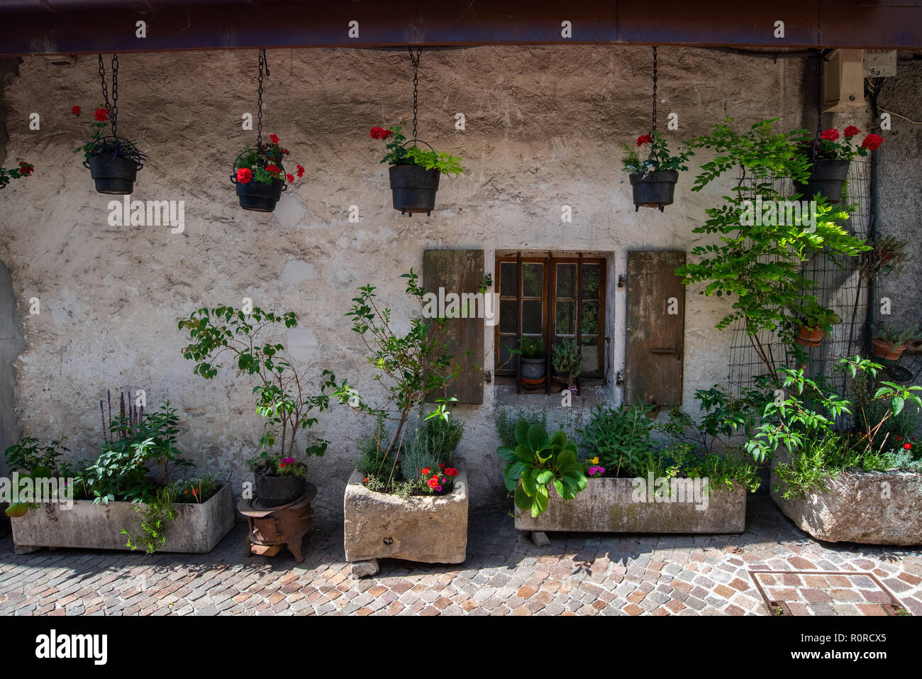 Devant une maison décorée de jardinières en pierre et de suspendre des seaux en fer faisant une très belle rue face à Annecy, France Banque D'Images