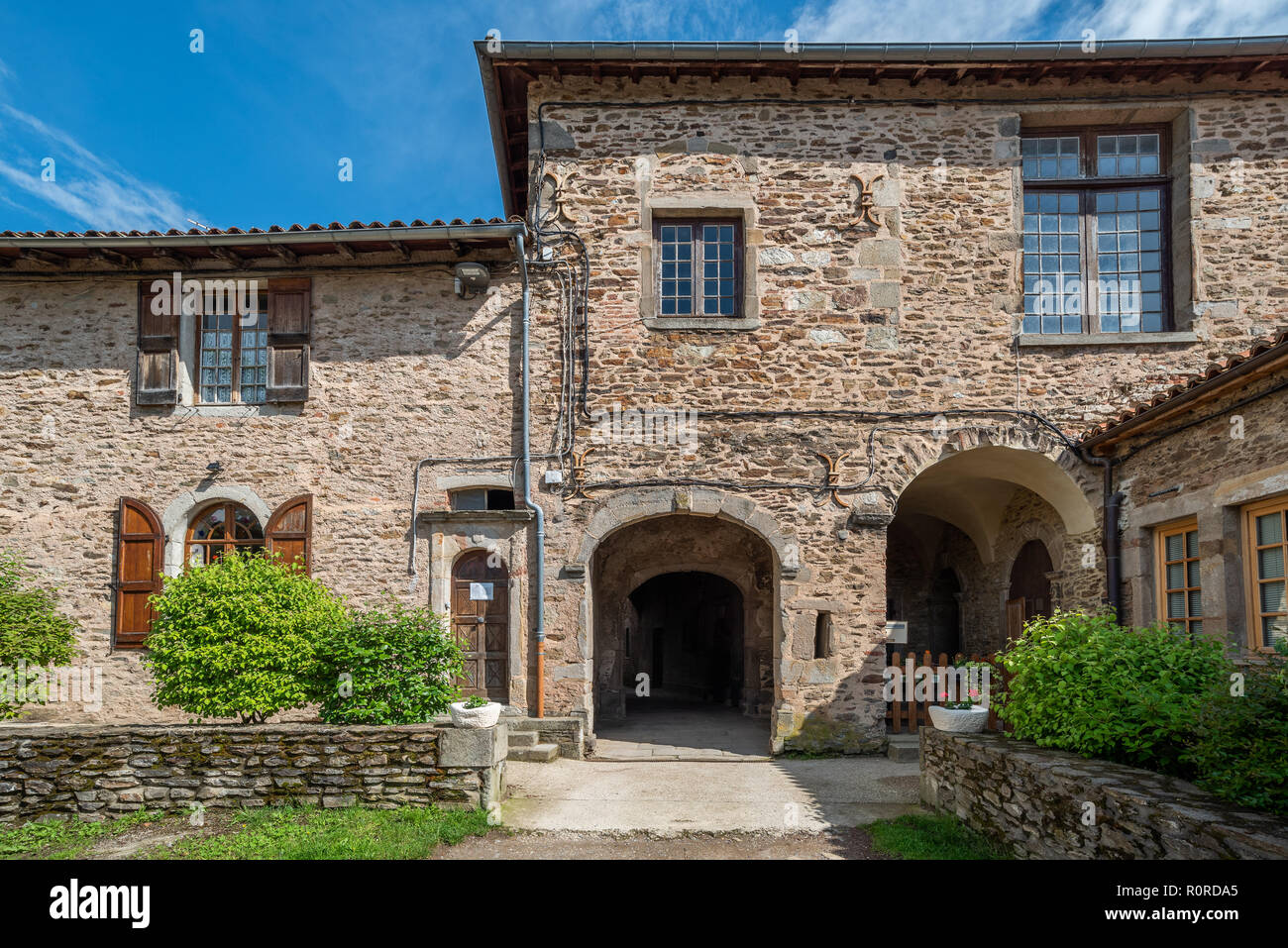 Les bâtiments monastiques avec des portes voûtées et des murs en pierre au hasard définir une cour externe dans le magnifique village de Farnay Banque D'Images