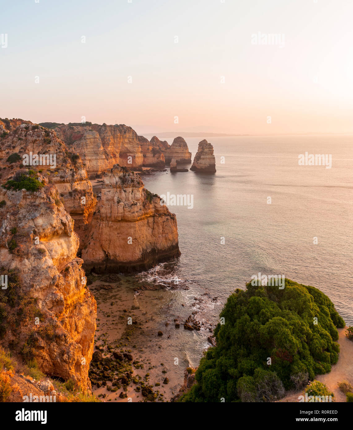 Lever du soleil sur la mer, côte rocheuse de grès, formations rocheuses dans la mer, Algarve, Lagos, Portugal Banque D'Images