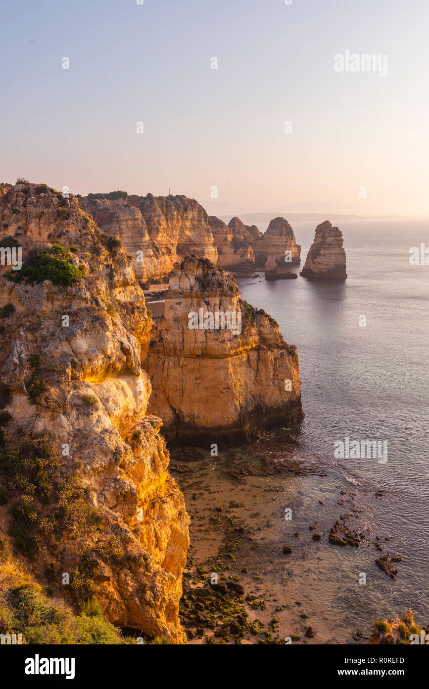Lever du soleil sur la mer, côte rocheuse de grès, formations rocheuses dans la mer, Algarve, Lagos, Portugal Banque D'Images