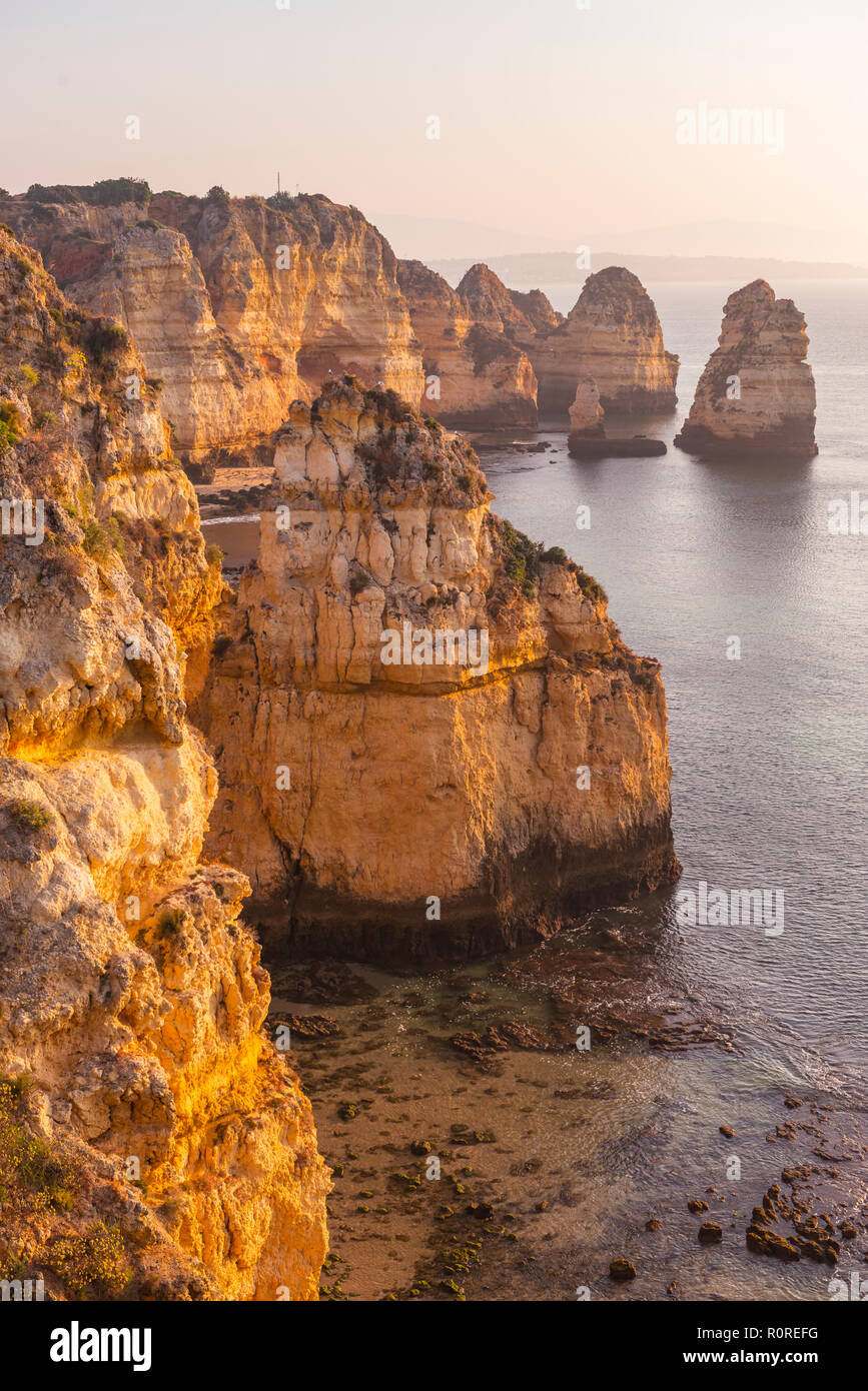 Lever du soleil sur la mer, côte rocheuse de grès, formations rocheuses dans la mer, Algarve, Lagos, Portugal Banque D'Images