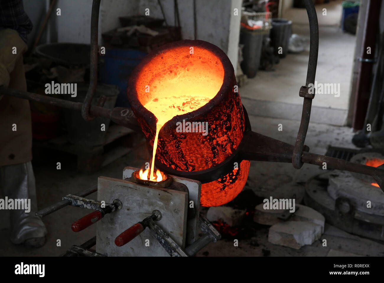Travailler dans une fonderie, bronze liquide est coulé dans le moule, Allemagne Banque D'Images