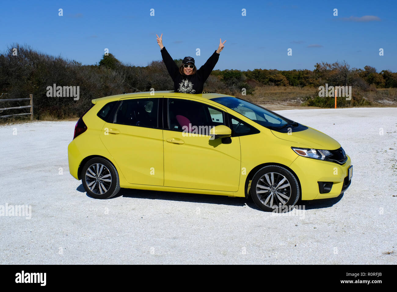 Femme chinoise à travers les commandes de son toit ouvrant Honda Fit jaune Banque D'Images